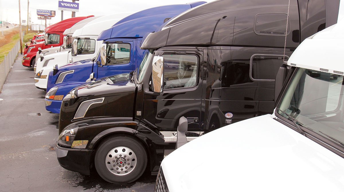 New Class 8 semi trucks lined up for sale on a dealership lot